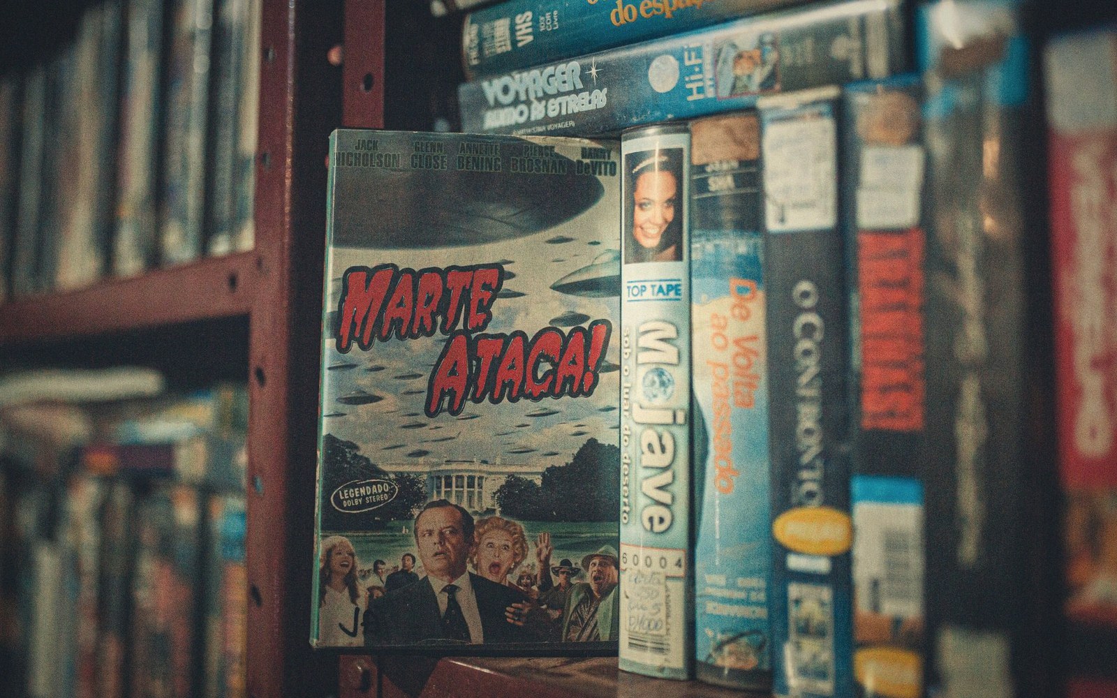 Rows of VHS tapes on a shelf, with "Marte Ataca!" cover facing forward